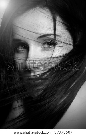 black and white portrait of a beautiful girl with hair blowing in her face