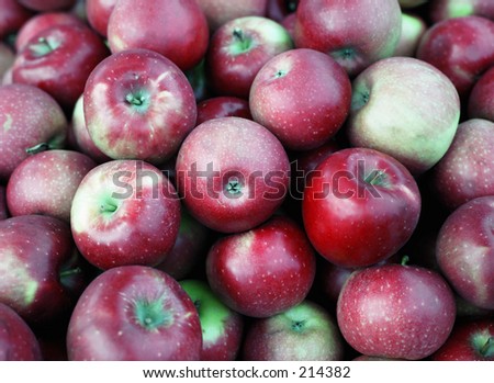 Large pile of red apples at a rural produce stand.