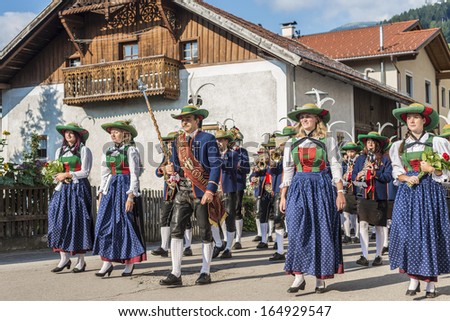 OBERPERFUSS, AUSTRIA - AUG 15: Villagers dressed in their finest traditional costumes during Maria Ascension procession along this village near Innsbruck on Aug 15, 2013 in Oberperfuss, Austria.