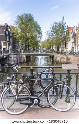 Typical bicycles, the most popular transportation system in Netherlands, parked on Amsterdam bank canal, Netherlands