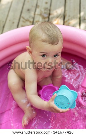 Little baby sitting in kiddie pool