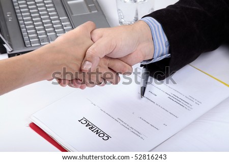 Deal. Handshake of business man and woman. Contract document in background