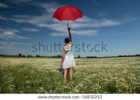 Want to fly. Woman with red umbrella above the head standing on meadow