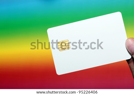 Blank credit card in female hand against the colorful background