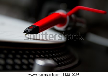 Professional DJ audio equipment - shperical turntable needle on white vinyl record