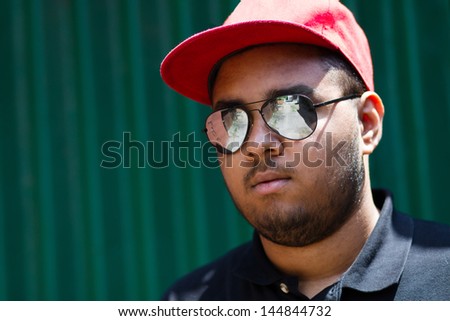 Cool young black man posing at the green garage wall on his block