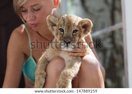 Photo set of people taking care of 2 month old male lion cub