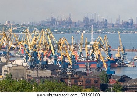 Industrial views of docks and big factory on the background. Heavy air polluiton is visible.