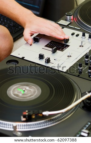 Hand of a disc jockey on the professional mixing controller