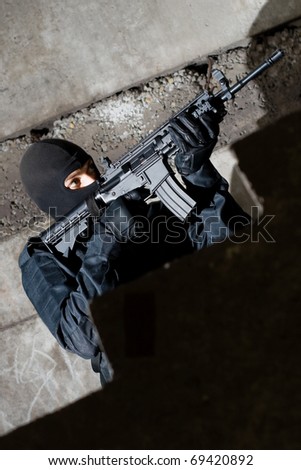 Armed and dangerous man in black uniform aiming the target