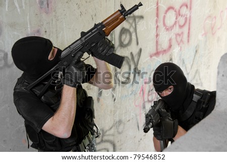 Photo of armed men in combat uniform playing terrorist or special forces team members