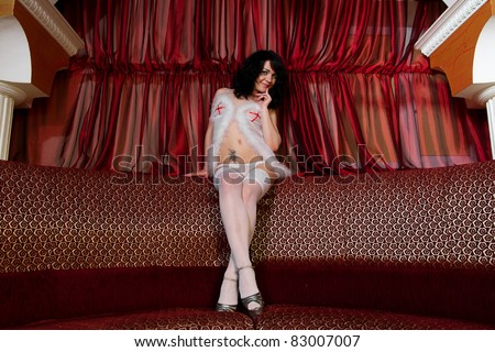 Young attractive woman in lingerie posing on the couch in the adult entertainment club