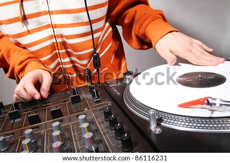 Disc jockey playing hip-hop music on professional top-class club equipment