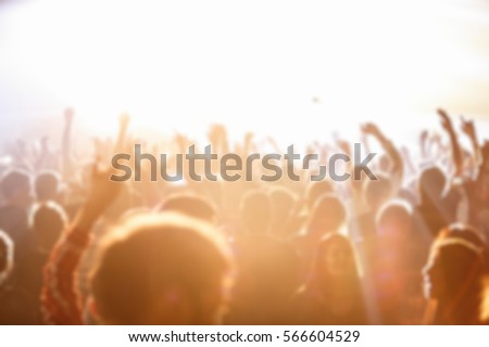 Blurry music festival with crowded dance floor in nightclub.Big live music show in night club.People have fun on concert.Huge concert crowd on fest.Fans audience wave hand to favorite singer sing song