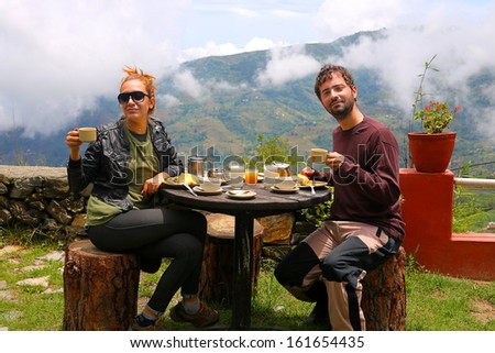 Tourist couple eating breakfast in himalayas mountains at Nagarkot, Kathmandu, Nepal