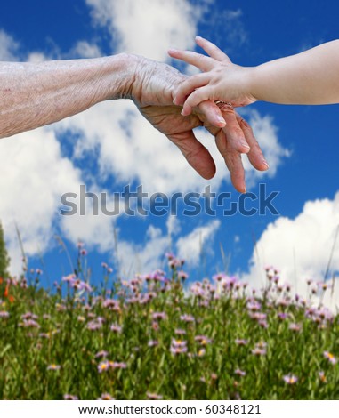 Young and old. Child\'s hand touching the elderly hand, connection of generations concept