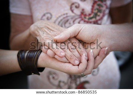 helping elderly people concept - young hands supporting old hand