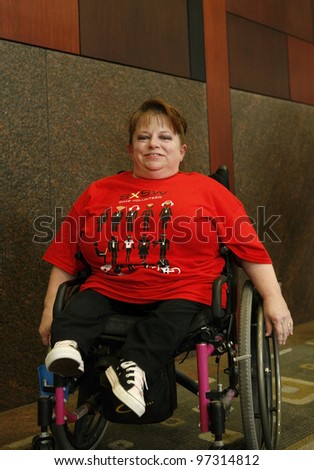 AUSTIN, TEXAS - MAR 9: SXSW 2012 South by Southwest 2012 Annual music, film, and interactive conference and festival on March 9, 2012 in Austin, Texas. Festival is held from March 9-18.   Wheelchair bound person in SXSW t-shirt attending the conference