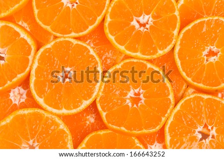 Background from overlapping slices of juicy seedless satsumas (Citrus unshiu)