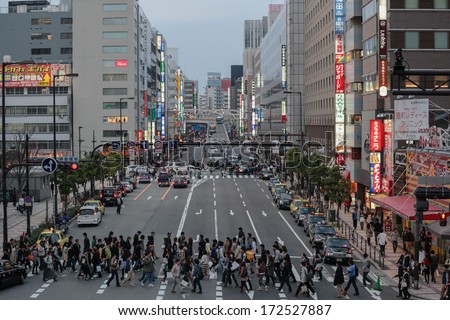 OSAKA, JAPAN - APRIL 09, 2011: Crowds cross Shibata street at dusk. It is located by Umeda, a major transportation hub in Kita-ku, Osaka that comprises Japan Railways Osaka and Umeda Stations.