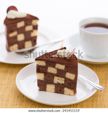 Vanilla and chocolate checkerboard cake makes a perfect tea time treat! The cake is garnished with whipped cream and cocoa powder, frosted with chocolate ganache.