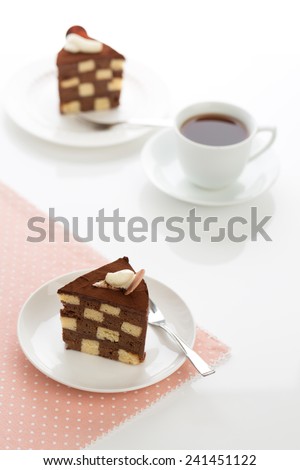 Vanilla and chocolate checkerboard cake makes a perfect tea time treat! The cake is garnished with whipped cream and cocoa powder, frosted with chocolate ganache.