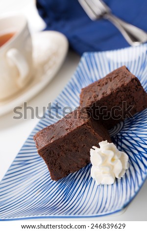 Chocolate brownies with whipped cream on a vintage rectangular porcelain plate with traditional Japanese \