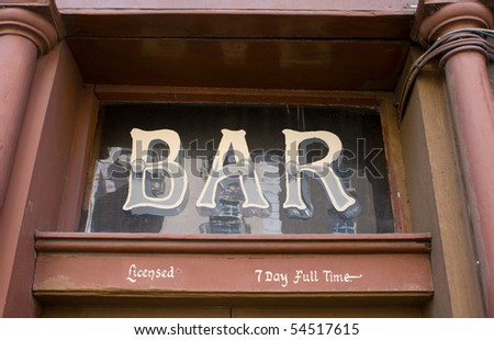 A sign reading Bar painted onto the glass over an Irish pub doorway.