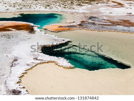 Doublet Pool is a steaming hot spring of geothermal-heated water with colorful complex deposits and thermophiles in Yellowstone\'s Upper Geyser Basin.