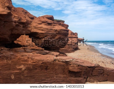 Red earth cliffs and arches along the eroding shoreline of Prince Edward Island, Canada