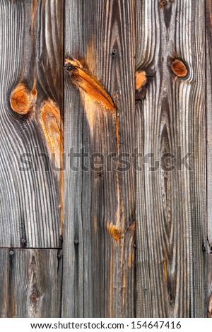 Old weathered wood displays textured grain and colorful knots.