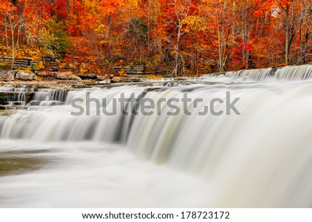 Brilliant autumn foliage surrounds the falling whitewater of Upper Cataract Falls, an Indiana waterfall.