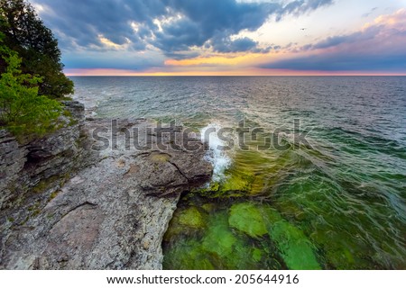 Waves break at dawn on the rocky coastline of Door County, Wisconsin\'s Cave Point.