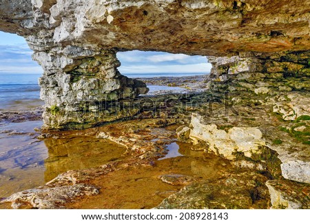 A rocky arch looks out on the waters of Lake Michigan at Door County Wisconsin\'s Cave Point.