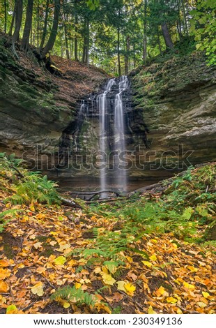 Tannery Falls, a waterfall near the Upper Peninsula Michigan town of Munising, pours over a rocky cliff in the autumn forest.