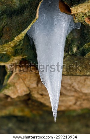 A single icicle catches the light as it hangs from a colorful stone cliff in Indiana.