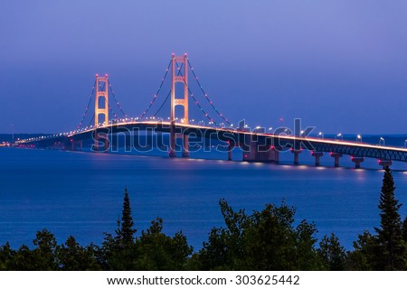 The Mighty Mackinac Bridge, connecting Michigan\'s Upper and Lower Peninsulas, carries vehicles over waters flowing from Lake Michigan and into Lake Huron.