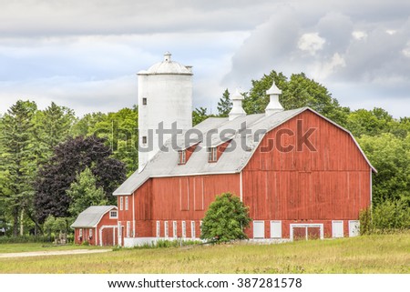 A large red barn with a tall white silo stands in scenic Door County, Wisconsin.