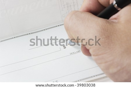 Macro, writing a check with a black pen.