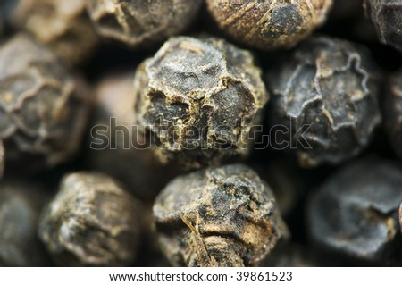 Macro image of whole black peppercorns with limited depth of field.