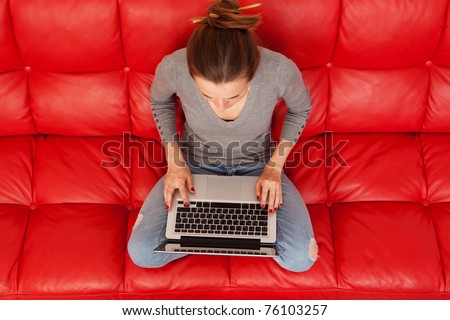 Top view of young woman working on laptop at home