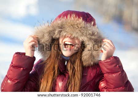 indoors winter portrait of young beauty in jacket with fur hood