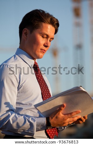 portrait of young good-looking successful businessman looking over the documents