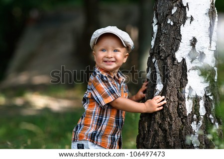 Boy hugs a tree in forest - child care ecology environment nature