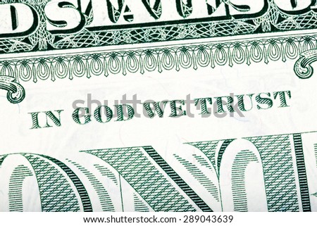 Dollar macro, stacked close-up detail photo. In God we trust sentence visible. One-dollar bill fragment. U.S. Treasury.