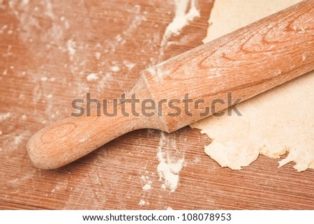 rolling pin with flour and dough on the table