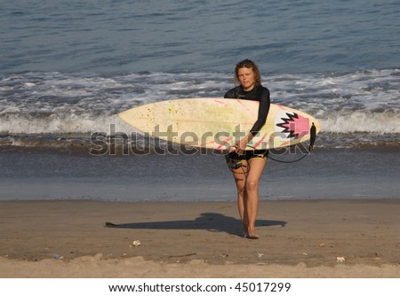 surfer girl going out from the ocean