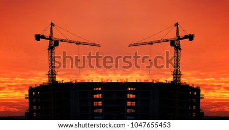 high tower crane above  skyscraper  constructing modern building all night long. Tower crane in red sunset sky background.
