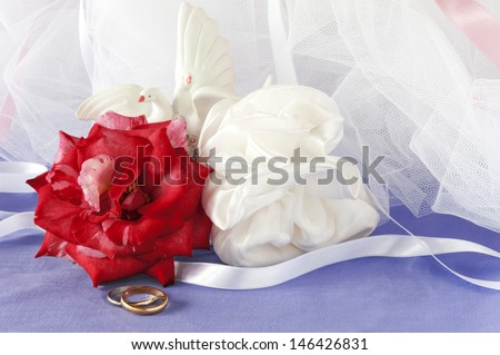 a wedding favors and wedding ring on colored backrgound