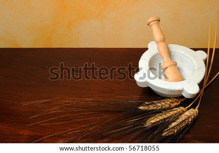 Flour, wheat ears and mortar on wood table